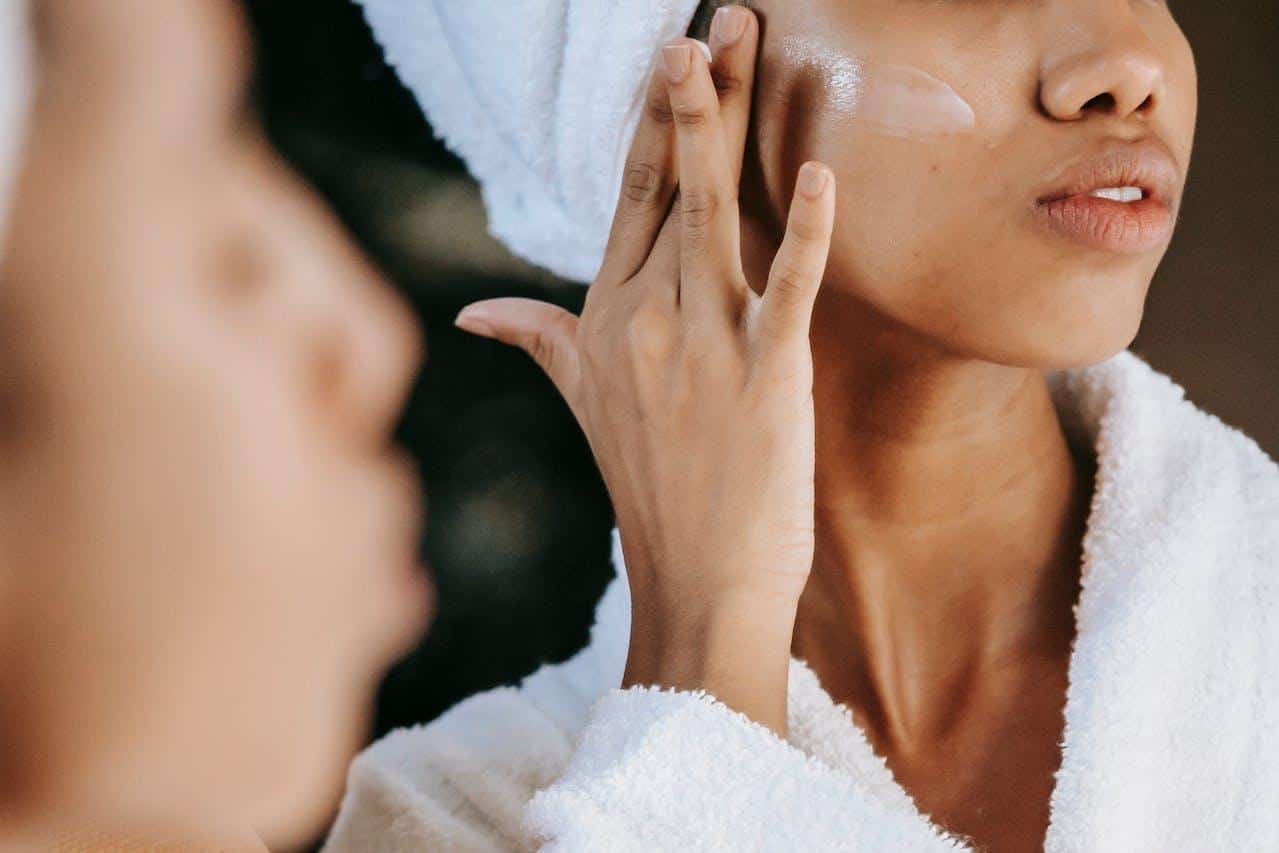 Woman applying face cream.