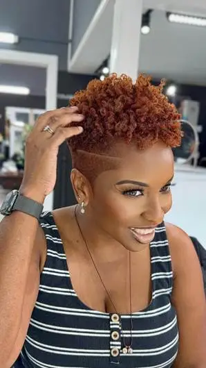 Woman with short curly hairstyle smiling in a salon setting