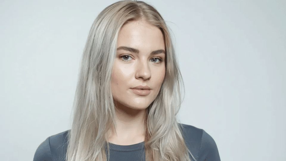 Woman with long ash platinum blonde hair in cool muted tones