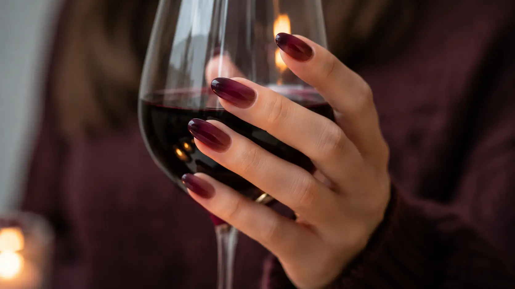Burgundy ombre nails holding a wine glass