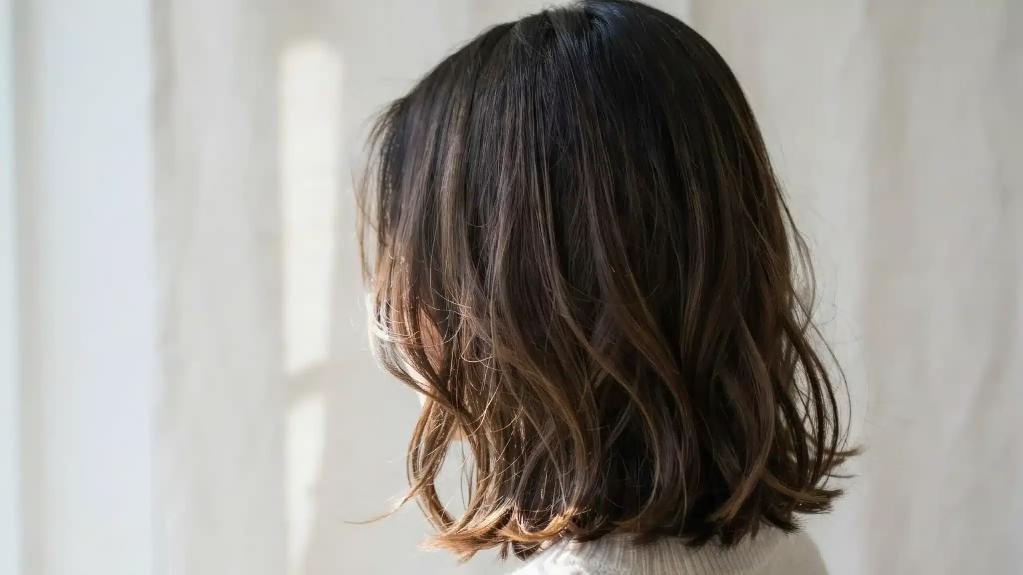 Black hair with fine caramel babylights evenly distributed.