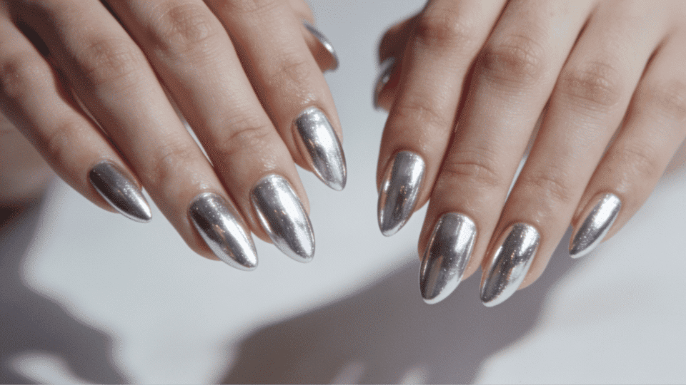 Almond-shaped nails with silver chrome finish, photorealistic mirrored manicure for parties.