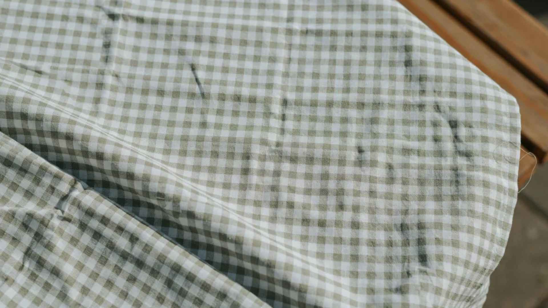 Close-up of a two-color gingham fabric with even, symmetrical checks and smooth cotton texture.