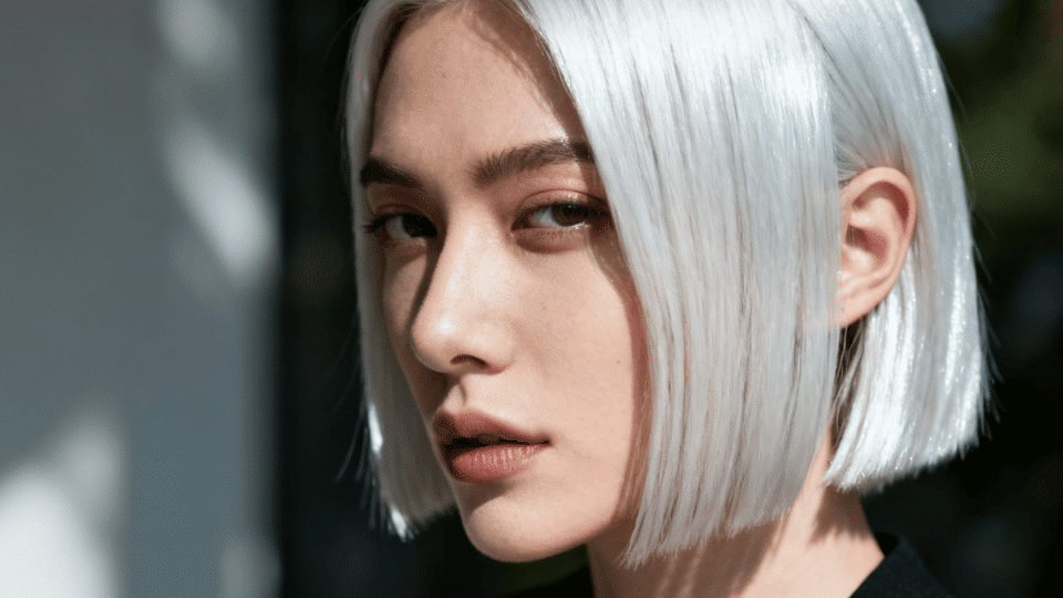 Woman with straight, sleek icy platinum blonde hair giving a bold, high-fashion look.