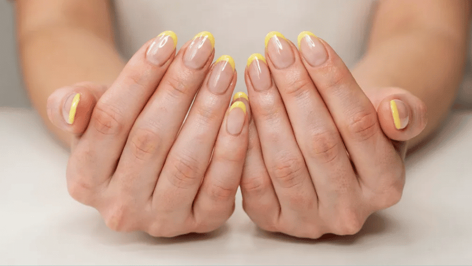 Almond nails with lemon yellow tips over sheer base, vibrant summer manicure, fresh and cheerful look.