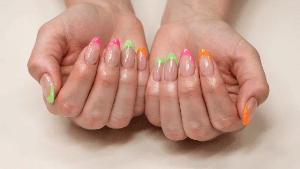 Almond-shaped nails with neon pink, green, and orange tips, glossy finish for bold summer looks.