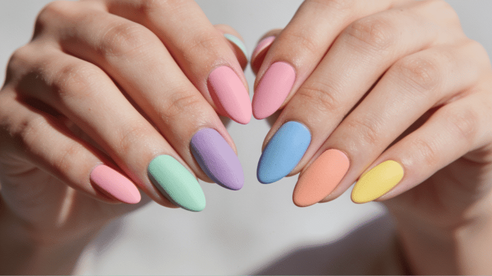 Almond nails in soft pastel rainbow shades, matte finish, playful and polished summer manicure.