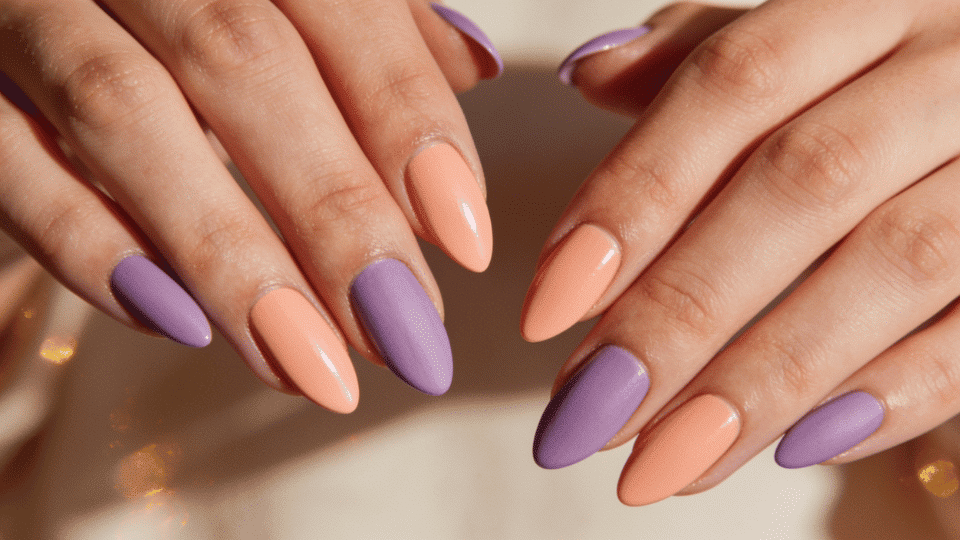 Almond nails in alternating peach and lavender shades with glossy finish, coordinated summer look.