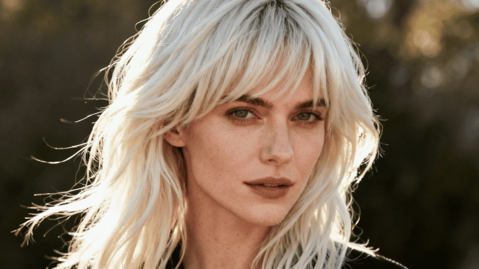Woman with long platinum blonde layered hair showing depth and movement.