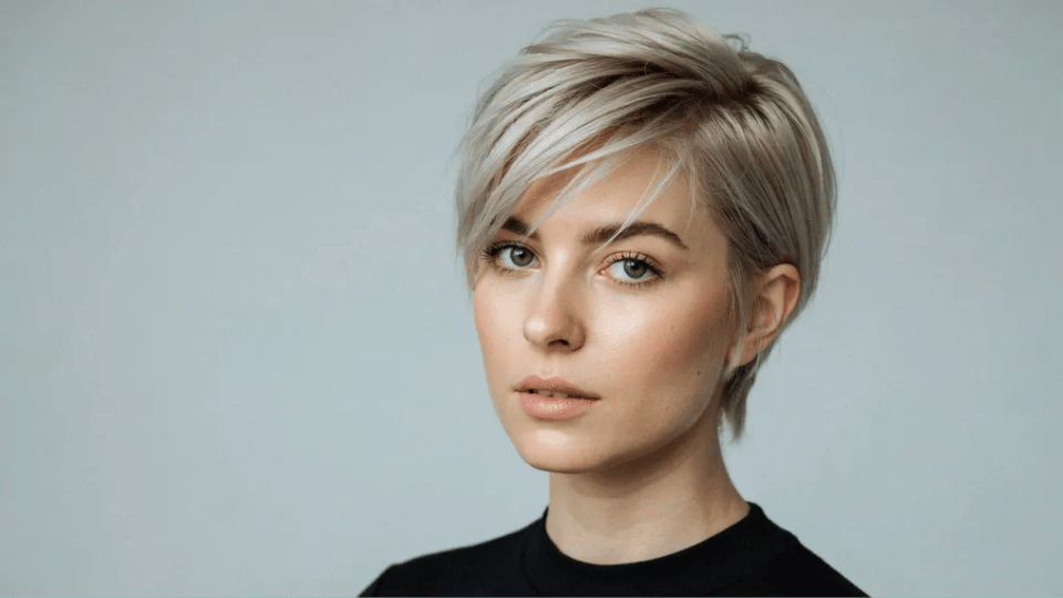 Woman with sleek short platinum pixie cut showcasing a bold, modern look