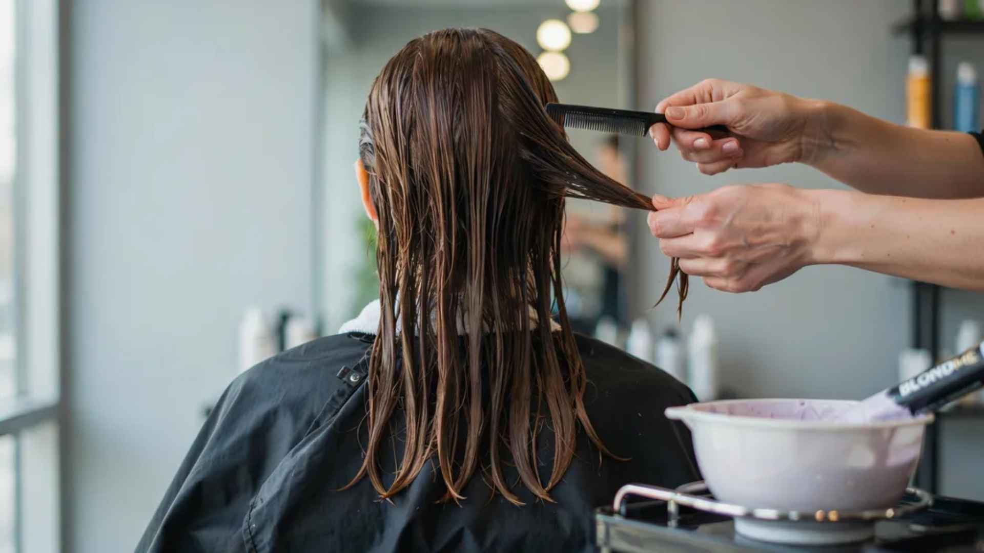 woman back view preparing hair for toner combing damp strands with petroleum jelly along hairline