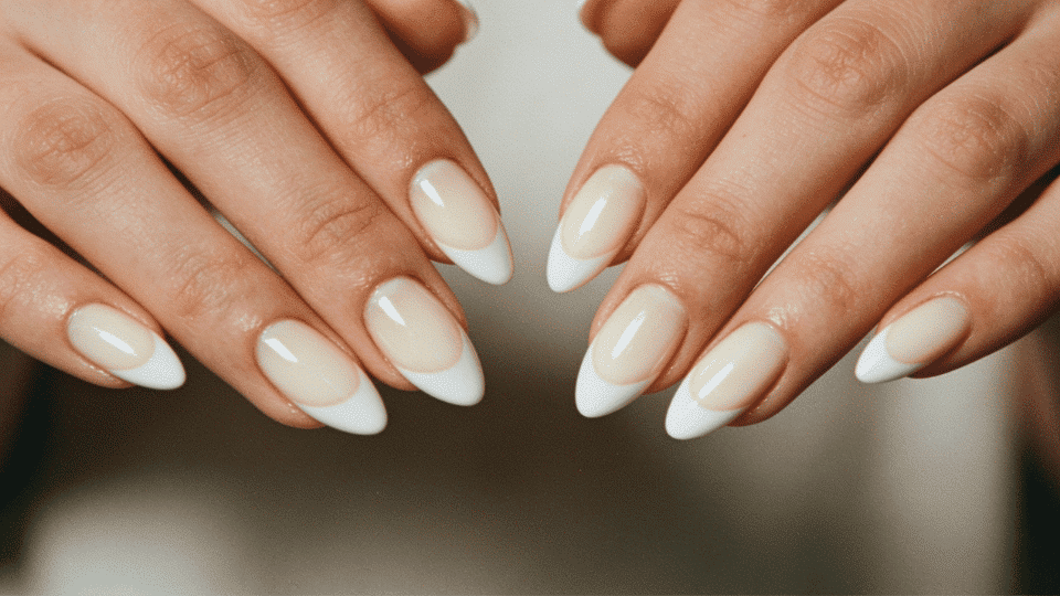 Hands featuring almond nails with creamy white tips, soft French-inspired manicure for casual wear.