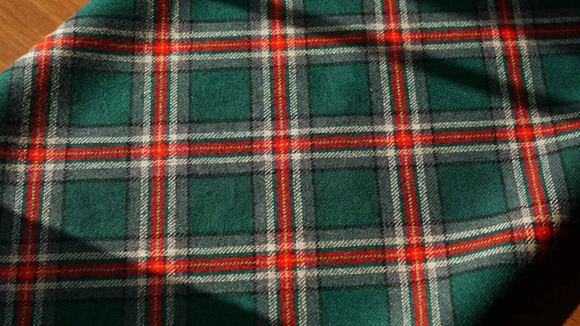 Close-up of a colorful Scottish tartan fabric with repeating sett and detailed woven texture.