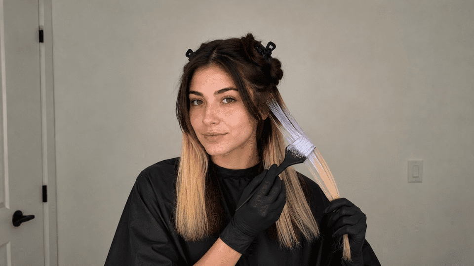 Woman applying toner to her pale yellow sectioned hair