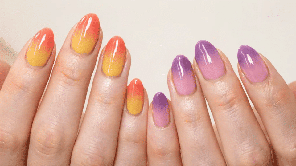 Almond nails with vibrant gradient ombré in coral, yellow, purple, and pink, eye-catching manicure.