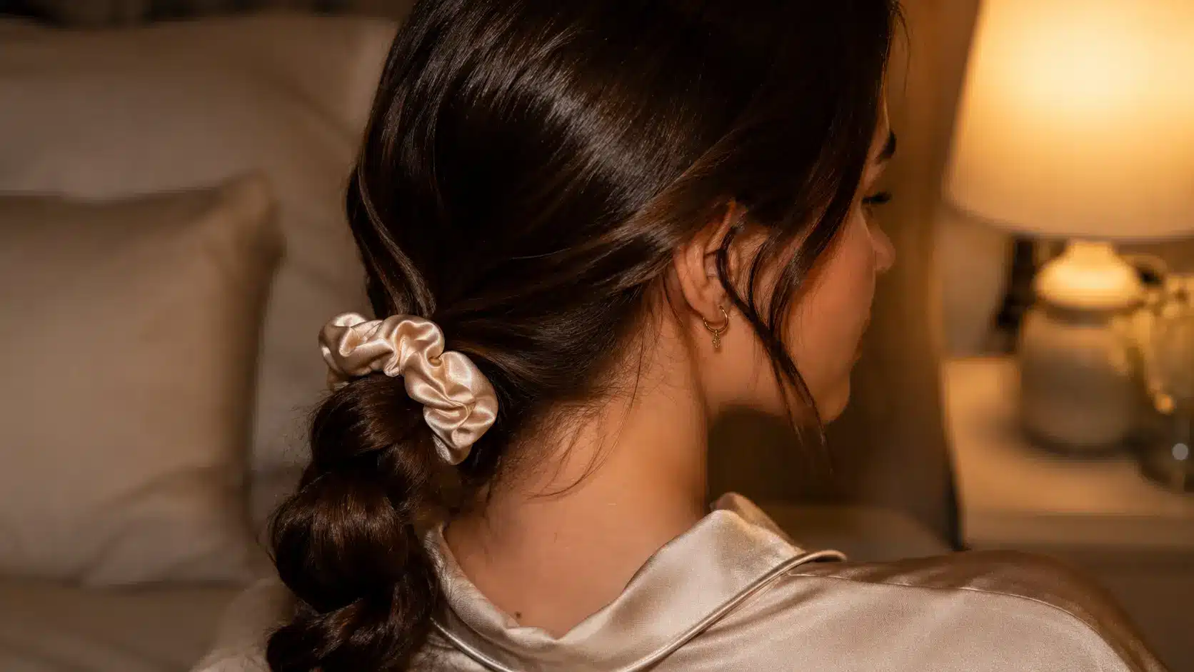 Woman wearing a loose low braid secured with a satin scrunchie for sleeping